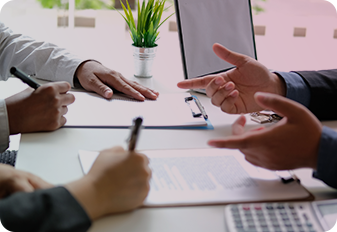 People talking at a desk with papers